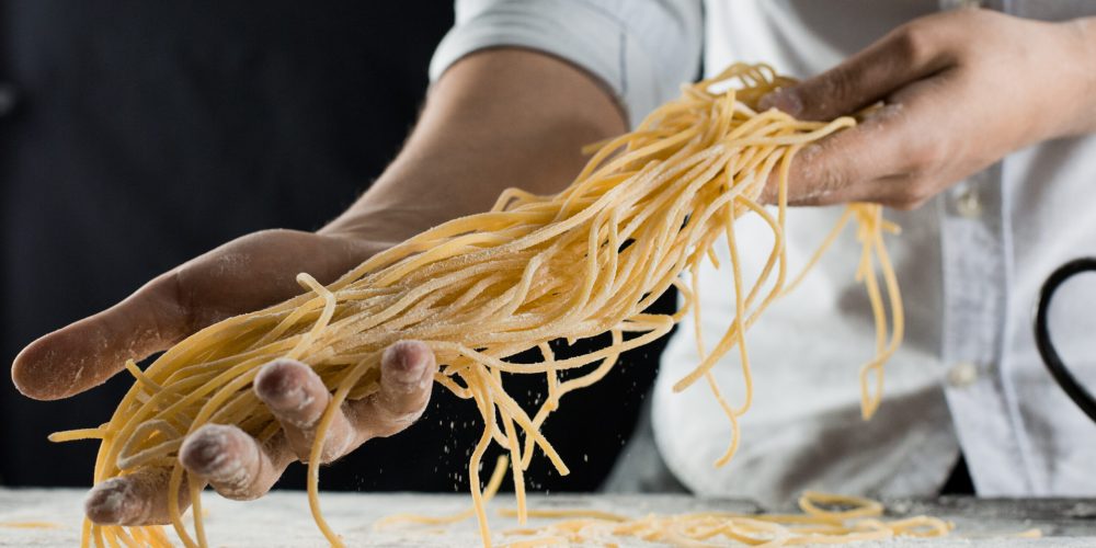 cook-holding-freshly-cooked-spaghetti-in-the-kitch-2021-10-21-02-26-02-utc-scaled.jpg